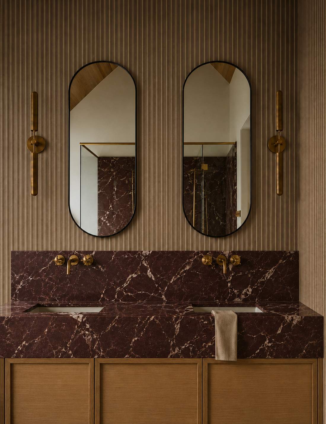 Pair of pill shaped bathroom mirrors above a marble vanity